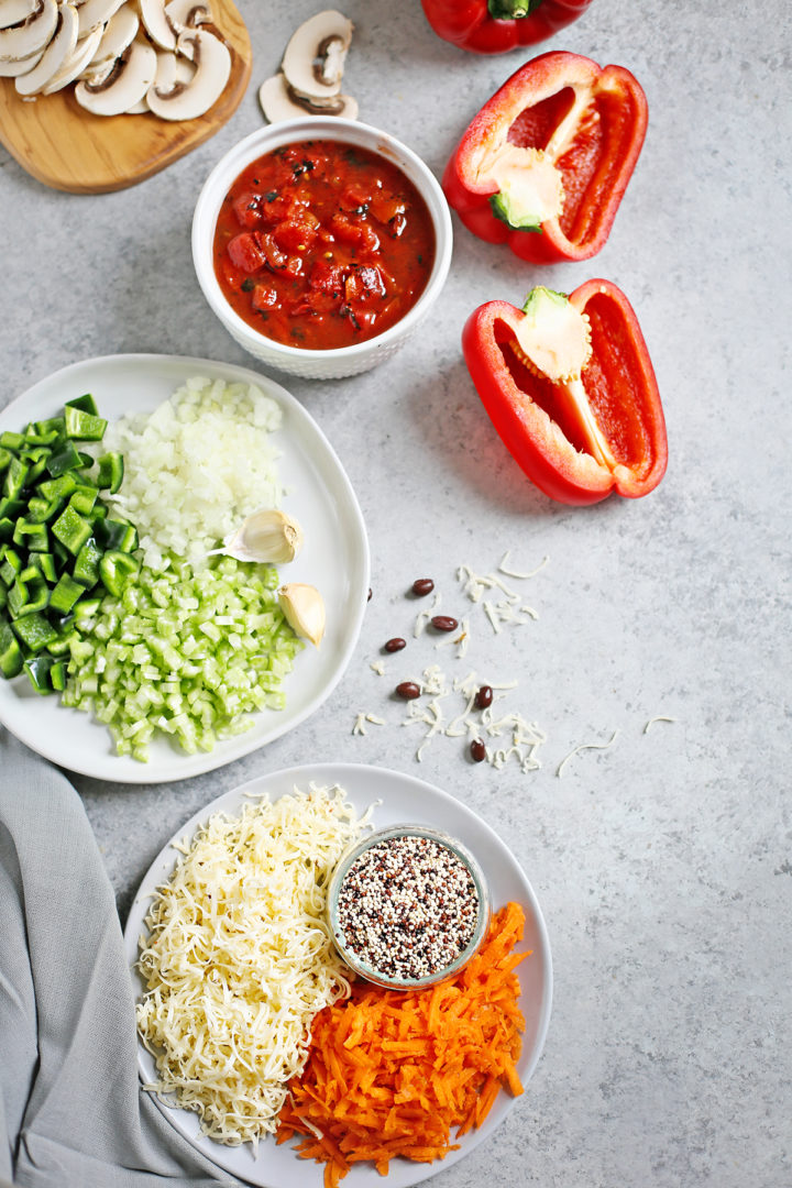 ingredients in quinoa stuffed peppers recipe arranged on a grey background