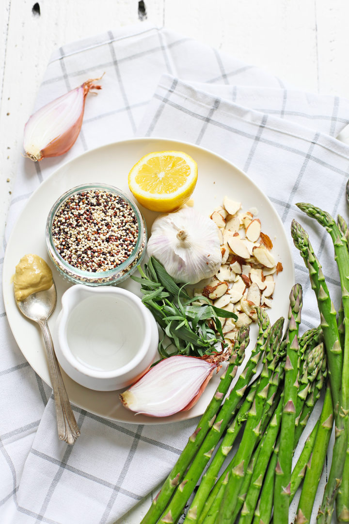 ingredients needed to make cold asparagus salad on a plaid kitchen towel and white plate