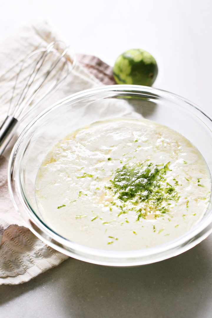 lime zest added to a bowl with other ingredients to make lime ice cream