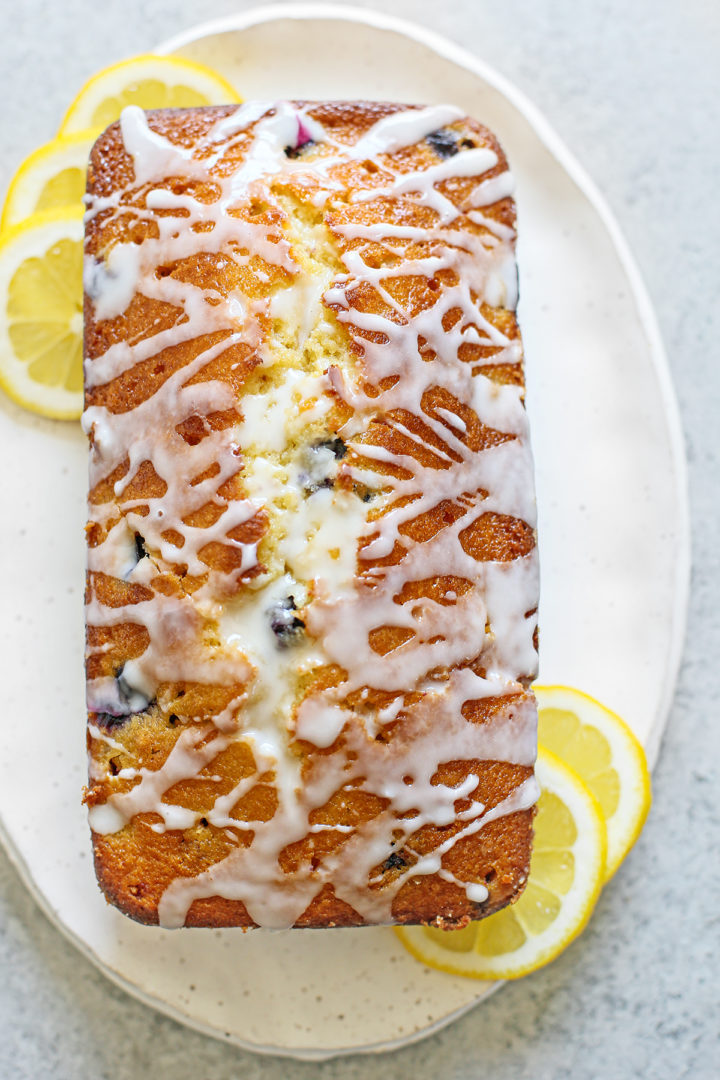 loaf of lemon and blueberry bread on a white plate