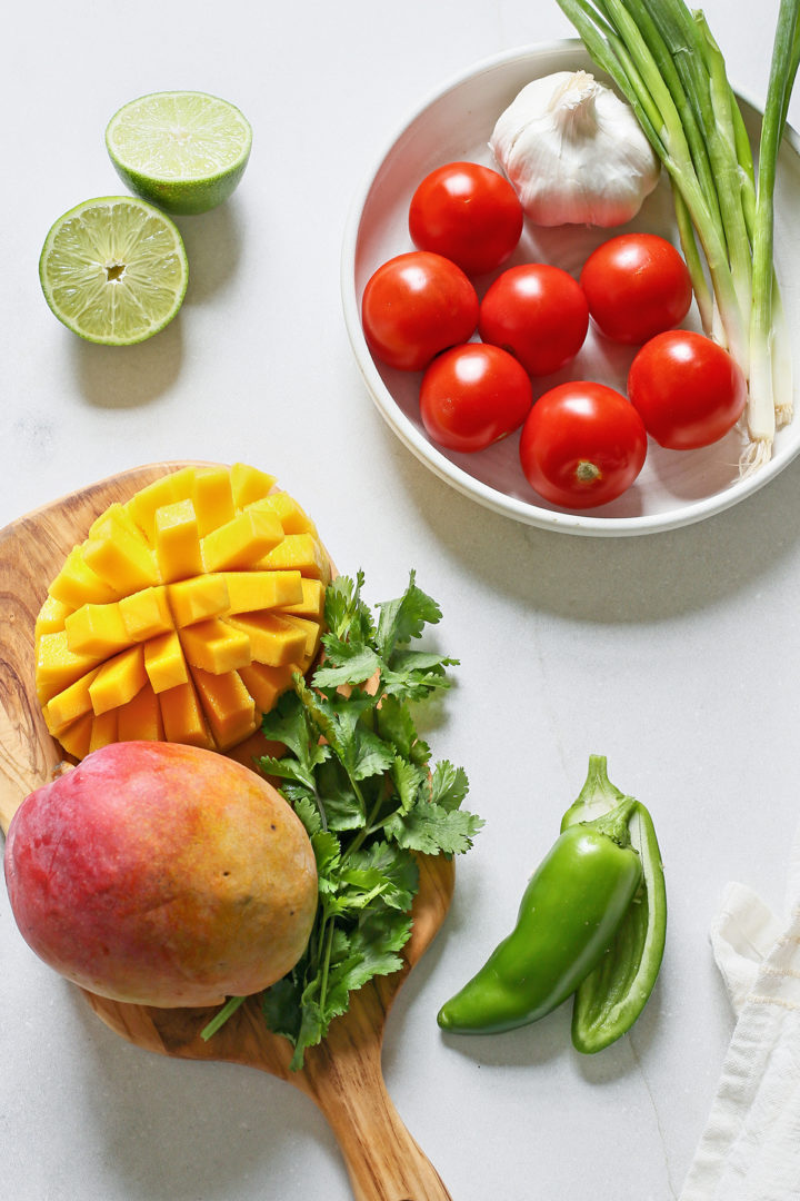 ingredients in this recipe for mango salsa arranged on a light countertop
