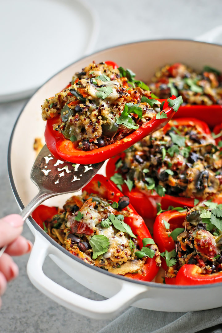 woman serving quinoa stuffed bell peppers