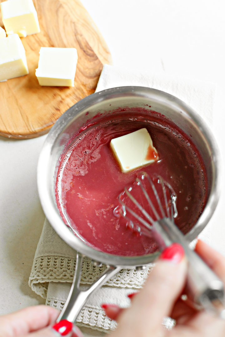 woman showing how to make raspberry curd, whisking butter into a saucepan