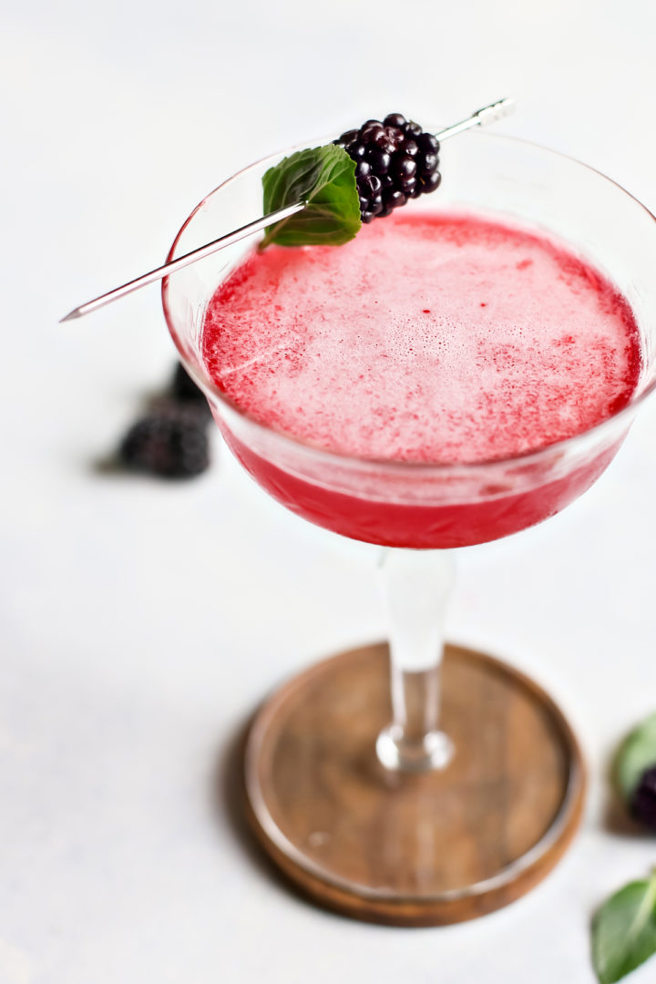 a cocktail glass filled with blackberry simple syrup