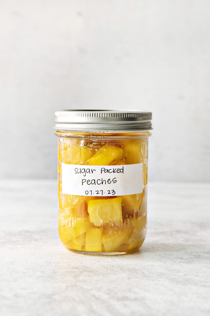 sugar packed peaches in a jar for freezing