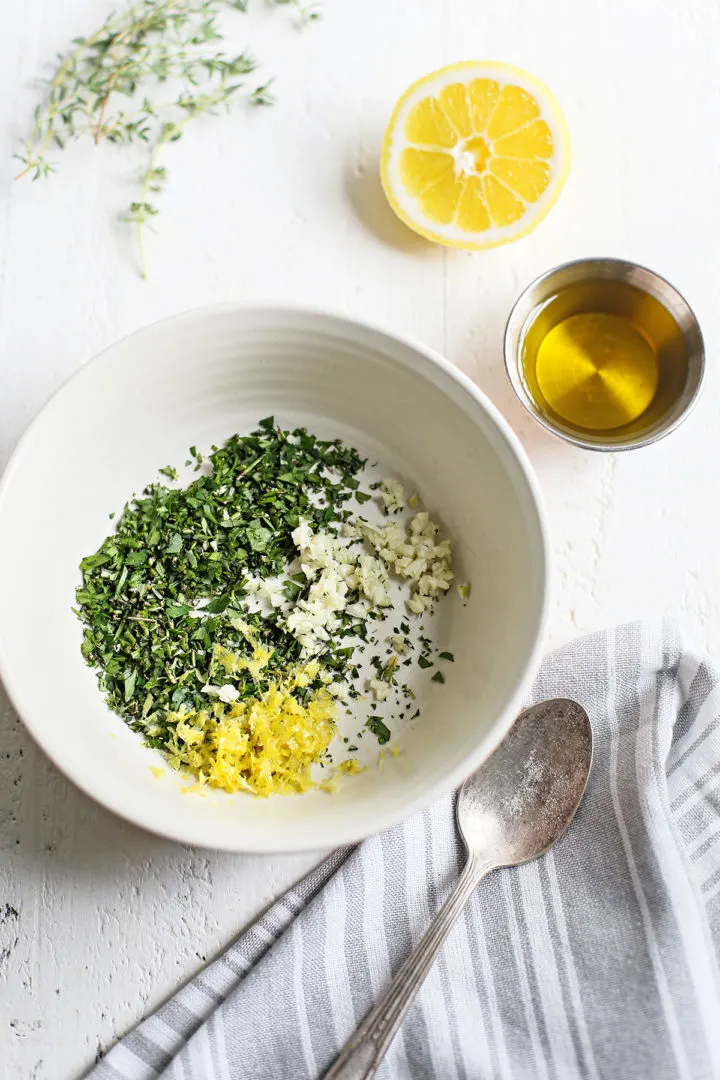 a bowl with chopped herbs, garlic, and lemon zest to make gremolata