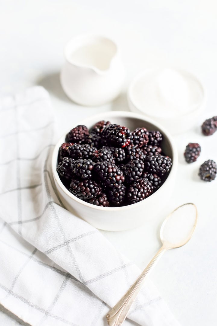 photo of fresh blackberries in a white colander for a tutorial on how to make blackberry simple syrup