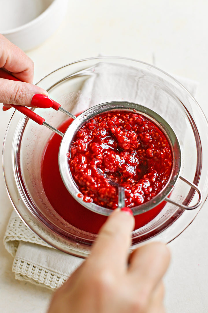 woman straining raspberries for raspberry curd recipe