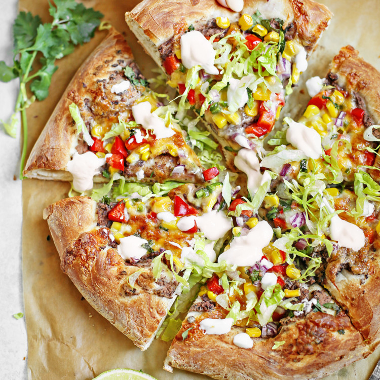 woman picking up a slice of mexican pizza