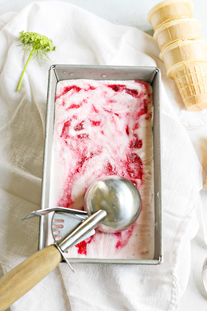 frozen strawberry yogurt in a metal ice cream dish with an ice cream scoop