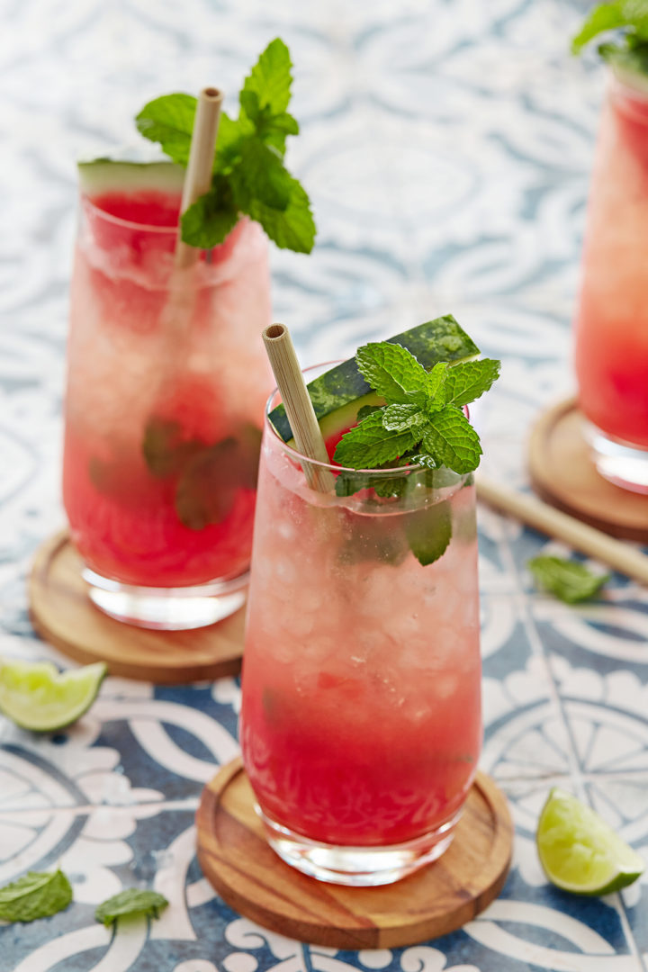 three glasses of watermelon mojitos on a blue tile counter