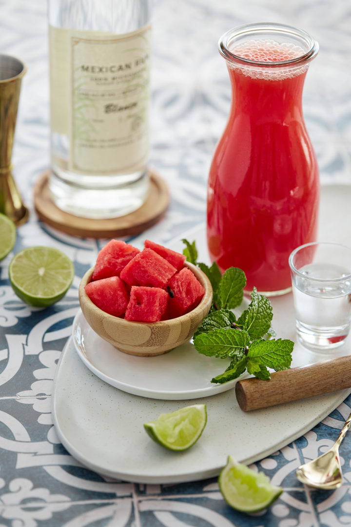 ingredients gathered on a a blue tile counter to make a watermelon mojito
