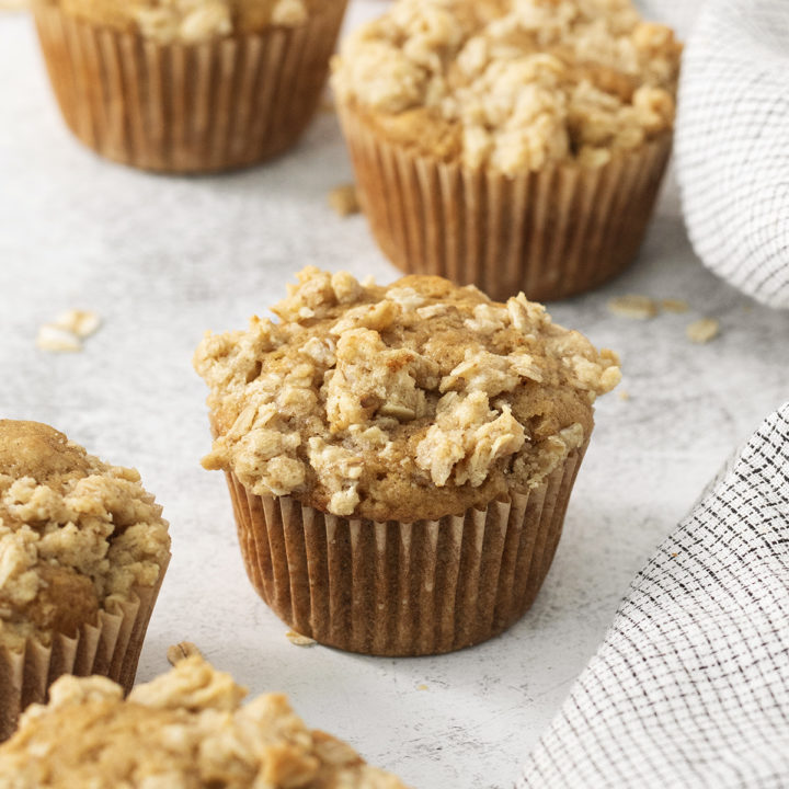 apple crumble muffins on a light background with a kitchen towel