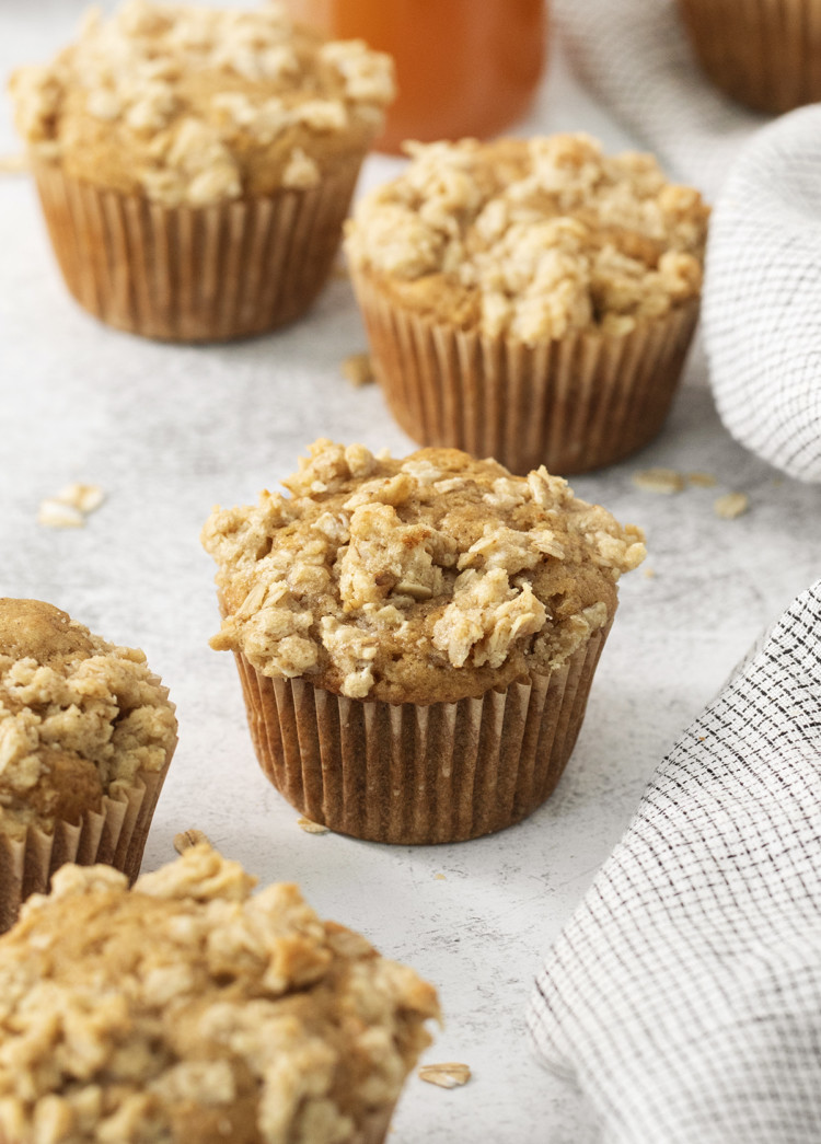 apple crumble muffins on a light background with a kitchen towel