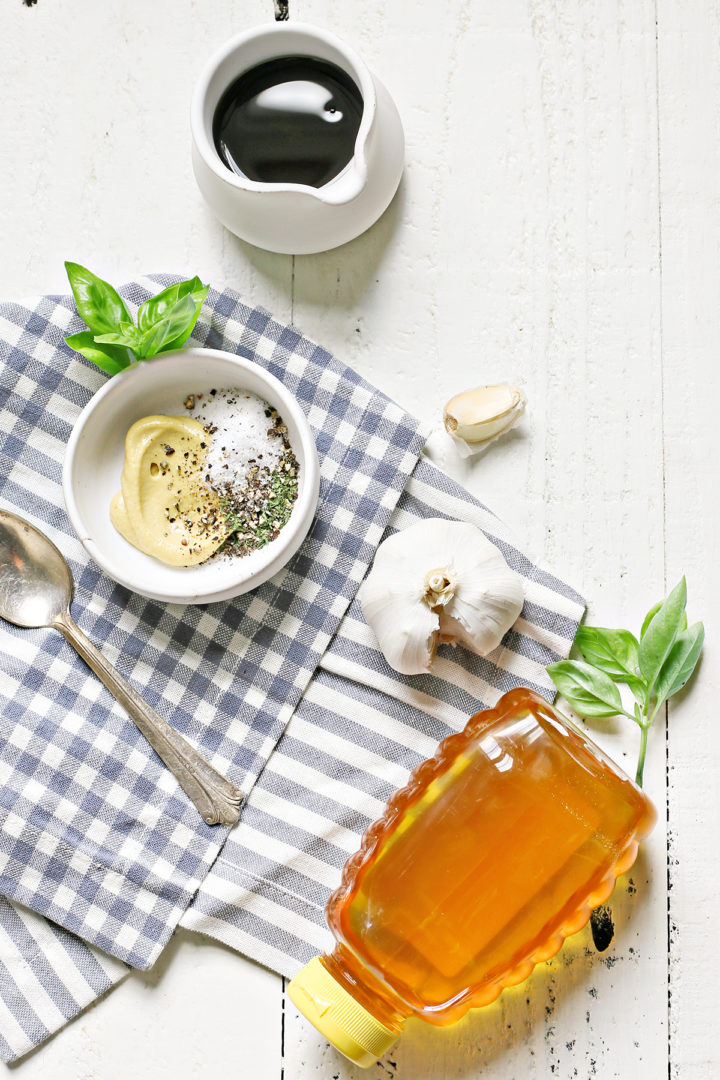 a white wooden table set with ingredients in balsamic chicken marinade