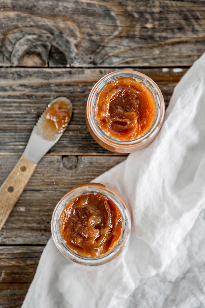 overhead photo of two jars of canned pear butter on a wooden table