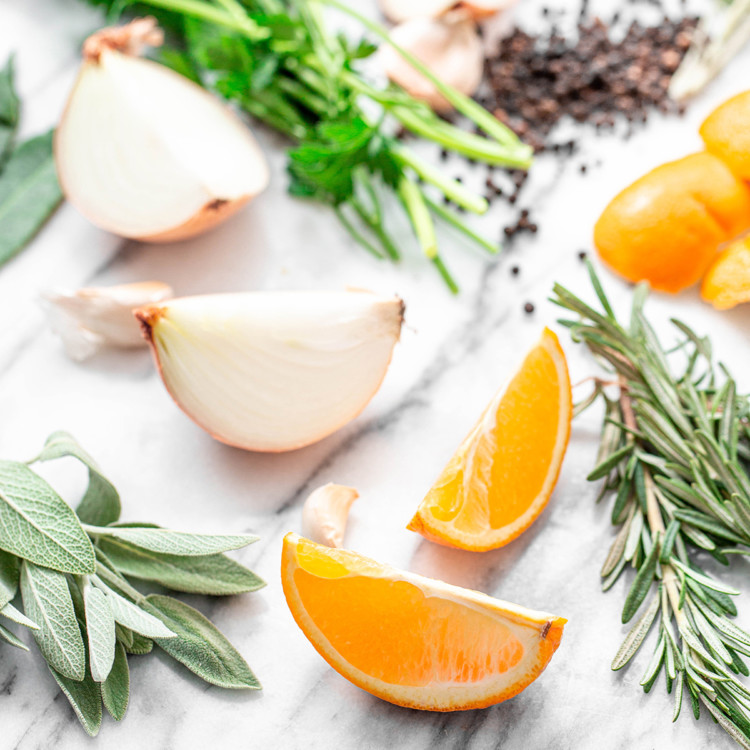 ingredients in citrus turkey brine: orange slices and fresh herbs on white background