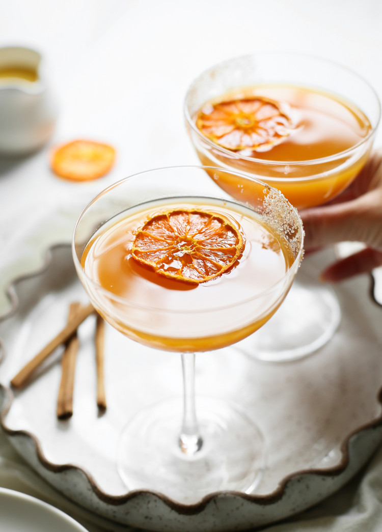 woman picking up a glass of pumpkin martini