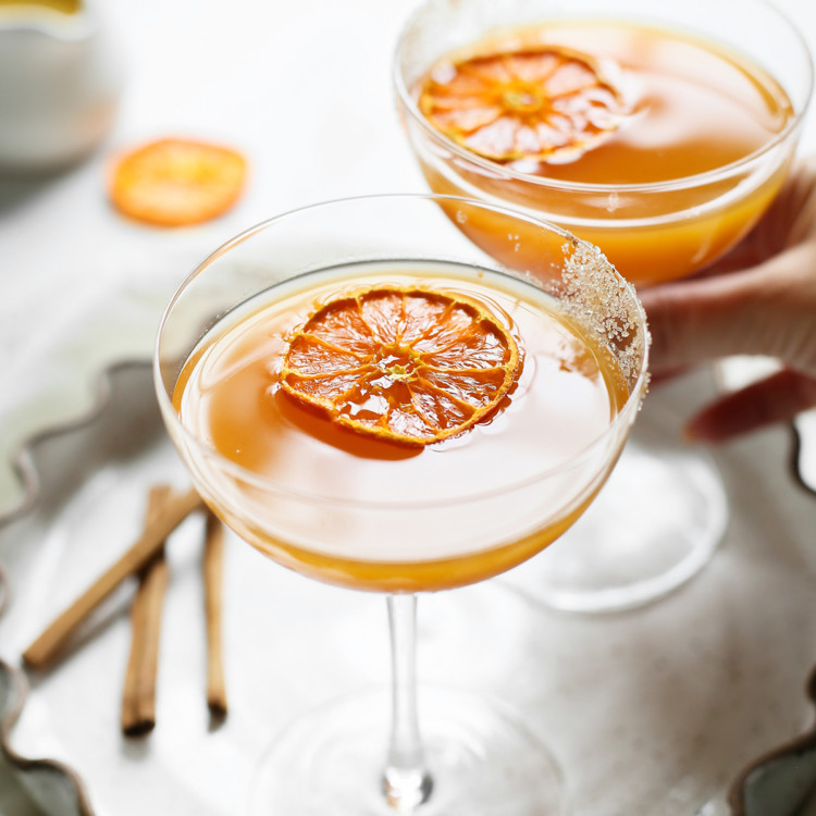 woman picking up a glass of pumpkin martini