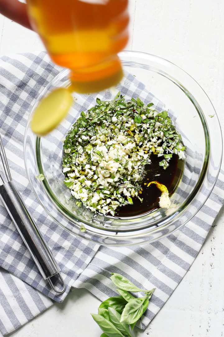 woman adding ingredients to a bowl of balsamic marinade for chicken