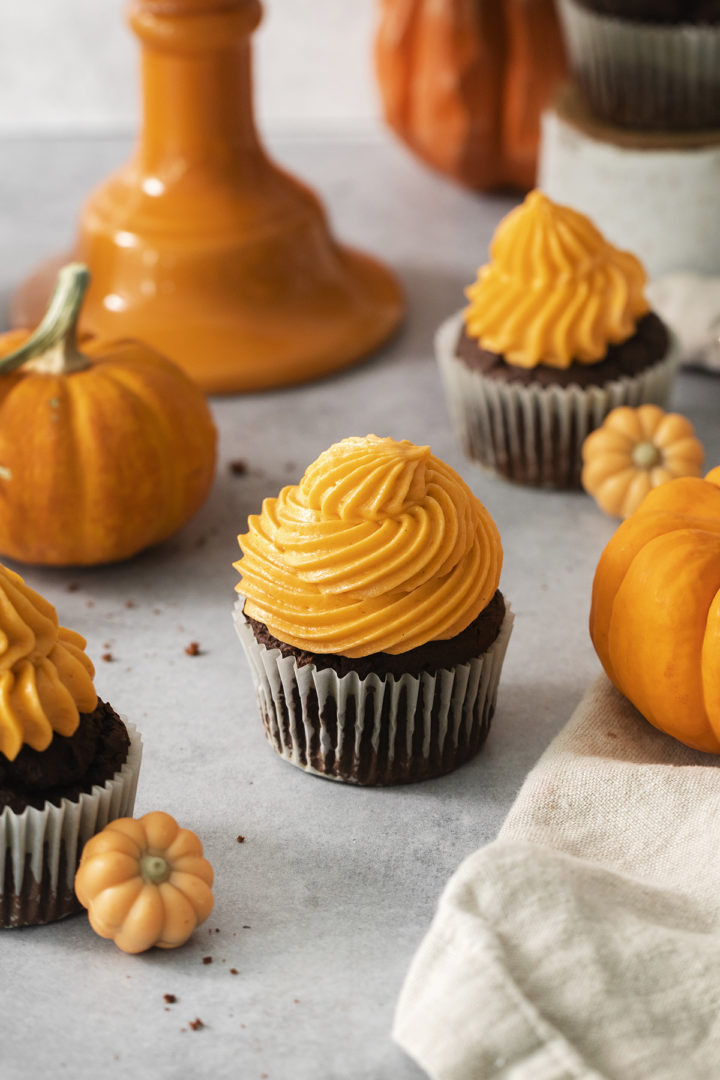 halloween cupcakes next to mini pumpkins