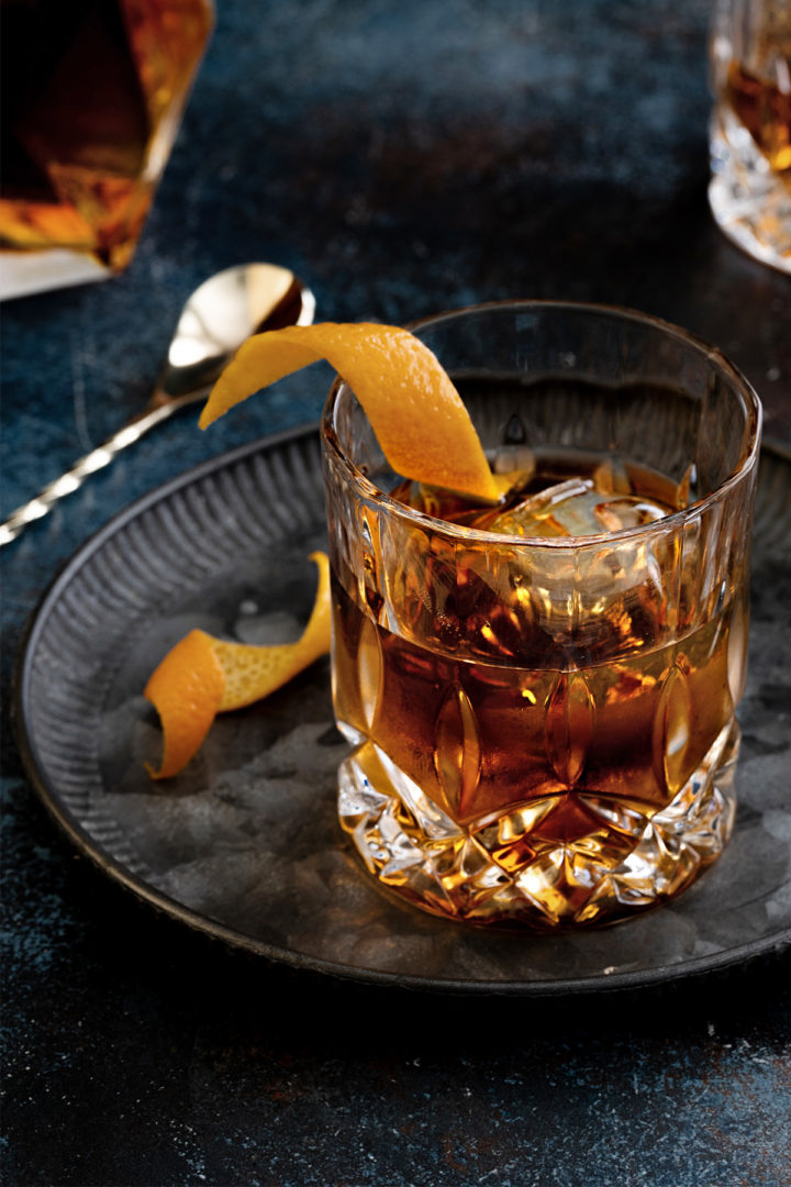 close up photo of a tequila old fashioned with an orange twist garnish