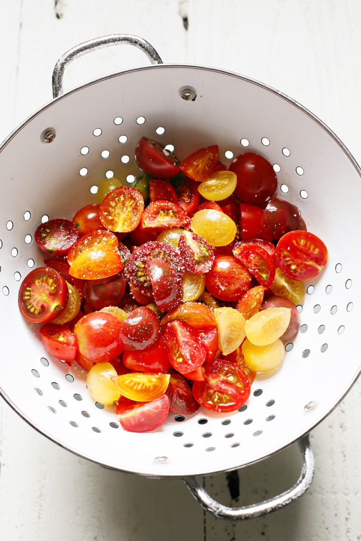 tomatoes in a colander being salted to make chicken bruschetta