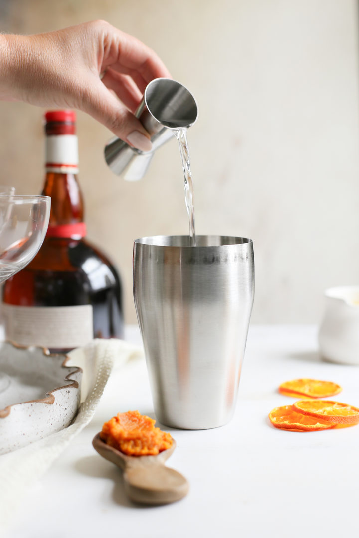 pouring vodka to make a pumpkin martini recipe