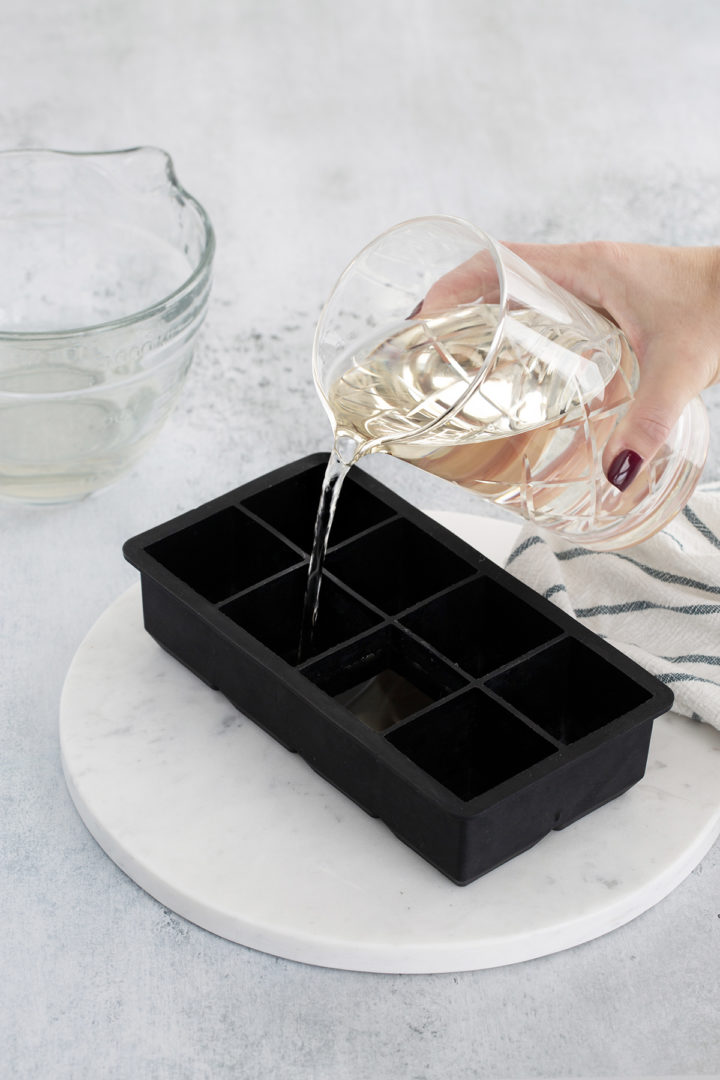 pouring smoked water into ice cube trays
