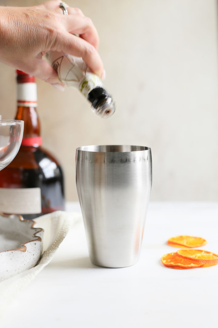 adding cocktail bitters to a pumpkin spice martini