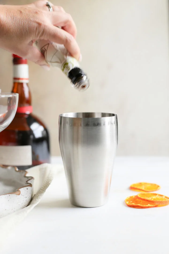 adding cocktail bitters to a pumpkin spice martini