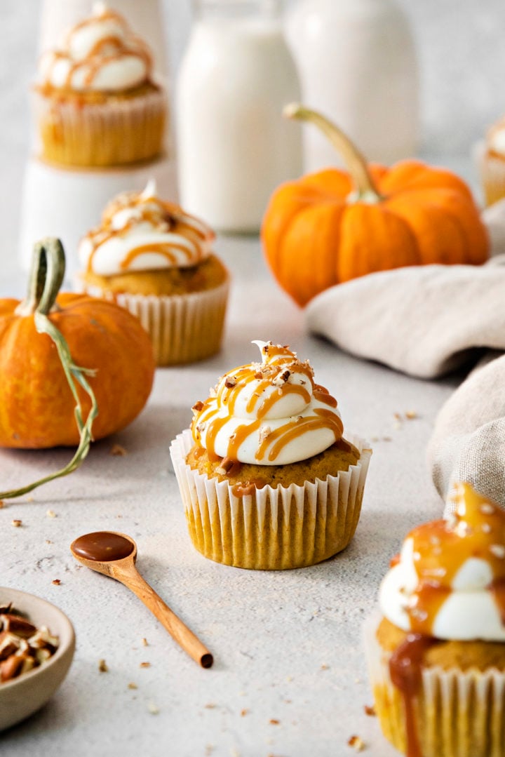 light background with pumpkin cupcakes with cream cheese frosting and mini pumpkins