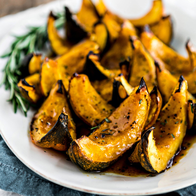 roasted acorn squash with apple cider glaze on a white serving platter