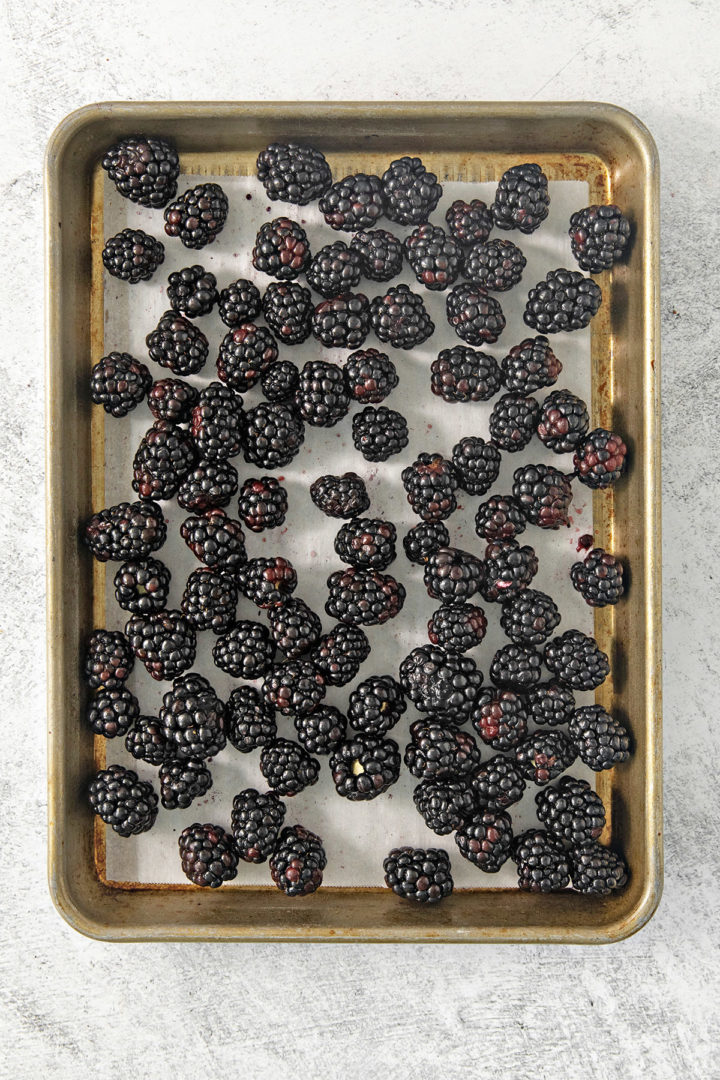 showing how to freeze blackberries on a baking sheet using the flash freeze method