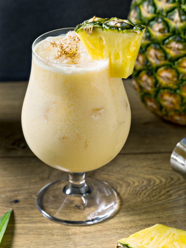 painkiller cocktail in a glass with a pineapple garnish