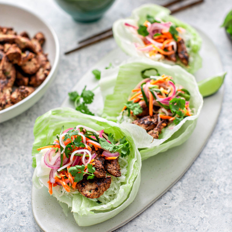 banh mi lettuce wraps on a serving platter with banh mi pork and pickled vegetables