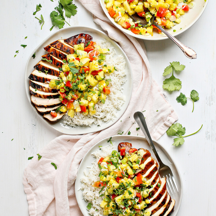 grilled chicken on a white plate with pineapple salsa
