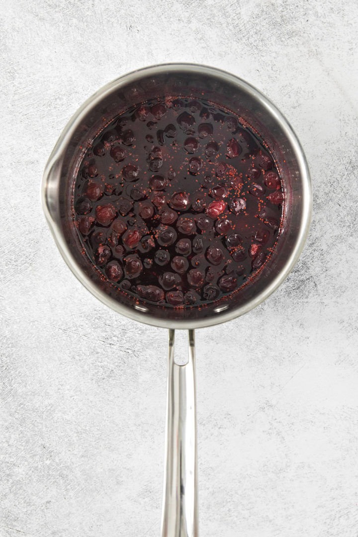 cranberry simple syrup steeping in a saucepan