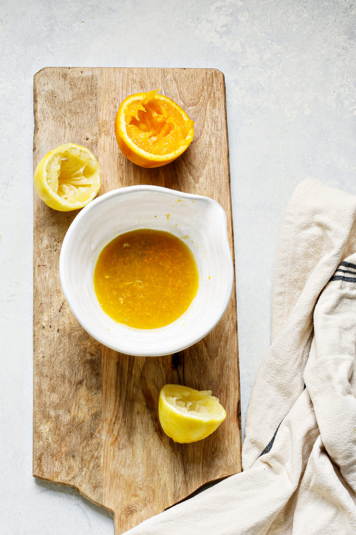 bowl of citrus juices on a wooden cutting board