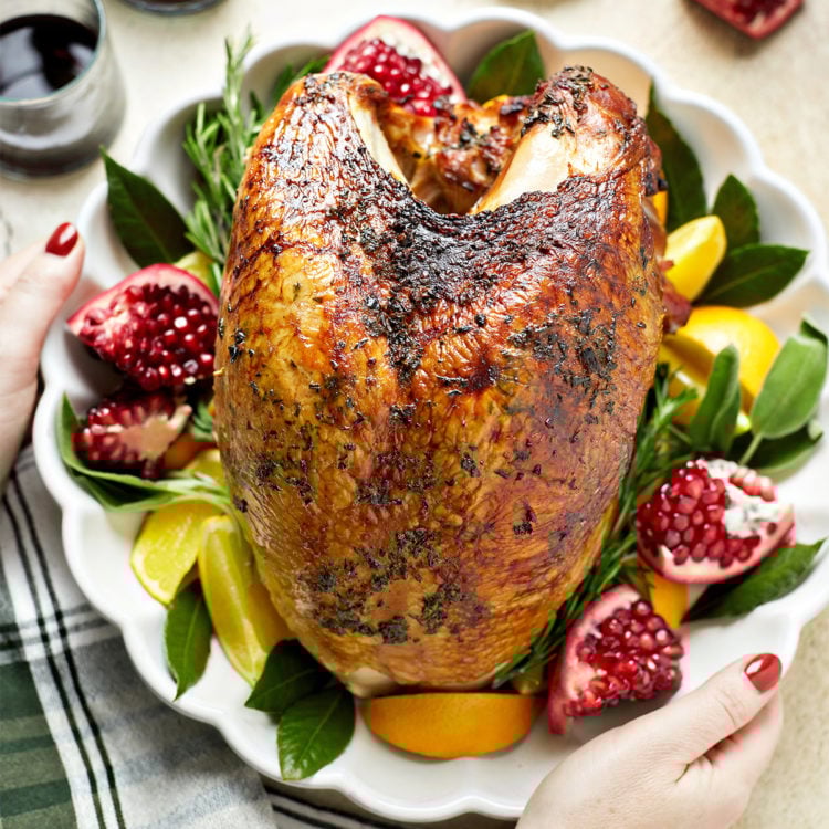 woman holding a thanksgiving turkey on a platter