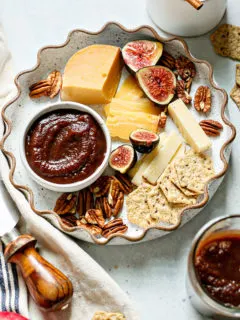 instant pot apple butter in a bowl on a plate with cheese and crackers