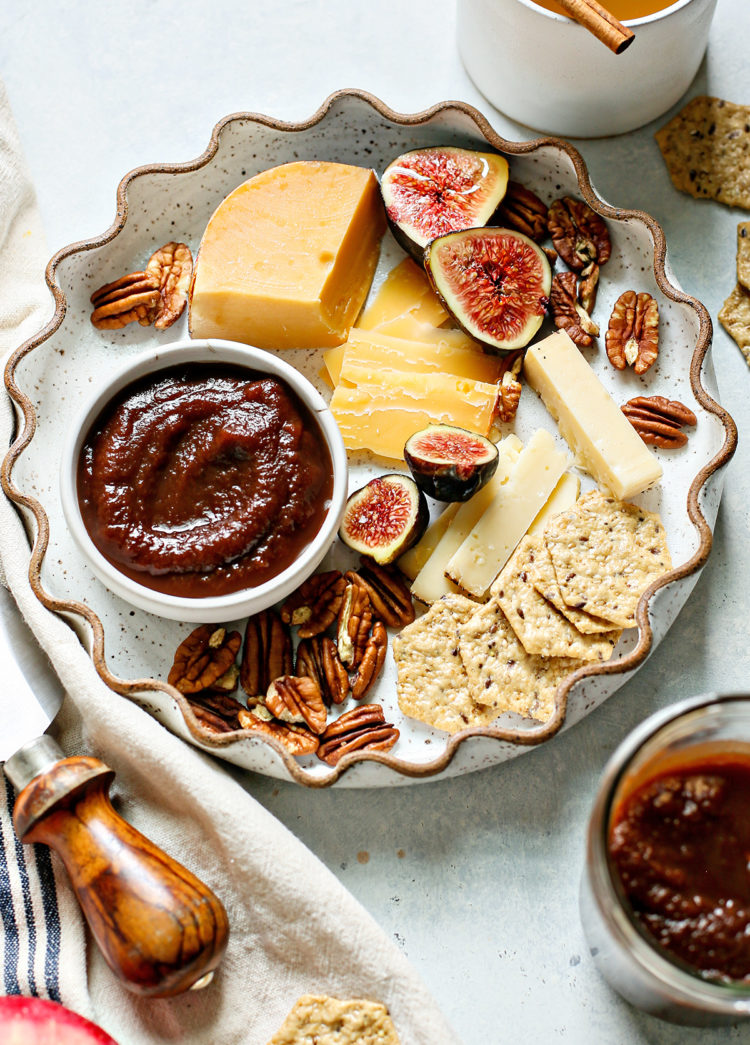 instant pot apple butter in a bowl on a plate with cheese and crackers