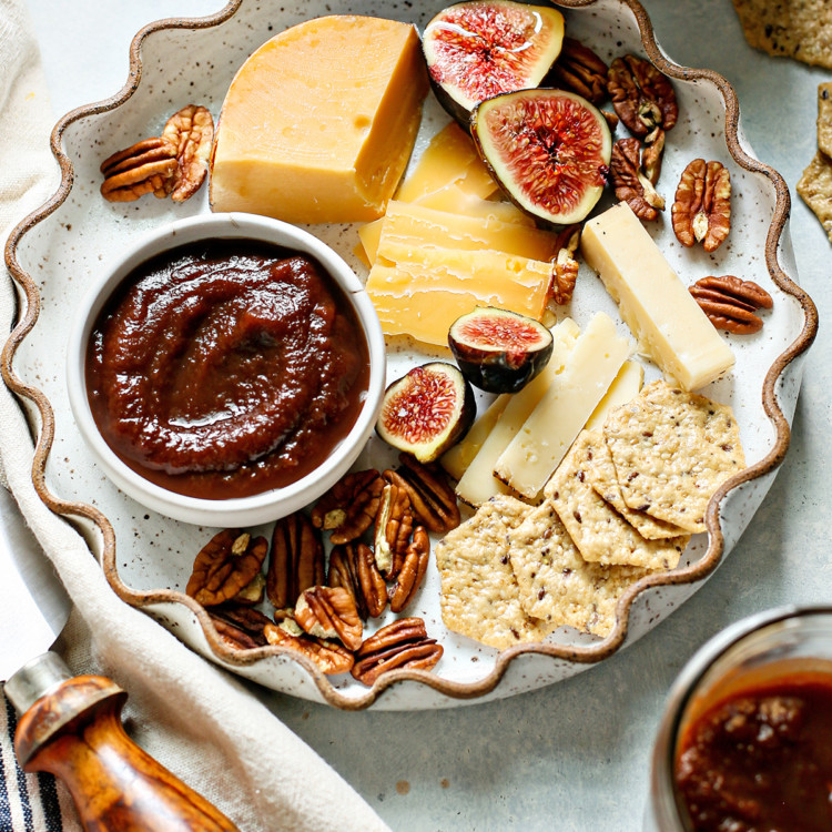 instant pot apple butter in a bowl on a plate with cheese and crackers