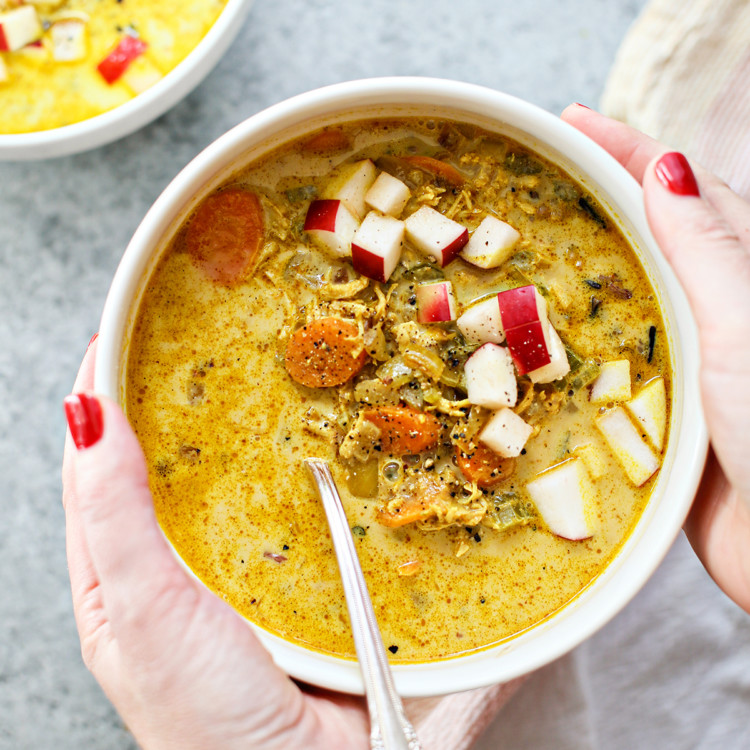 woman holding a bowl of spicy turkey soup