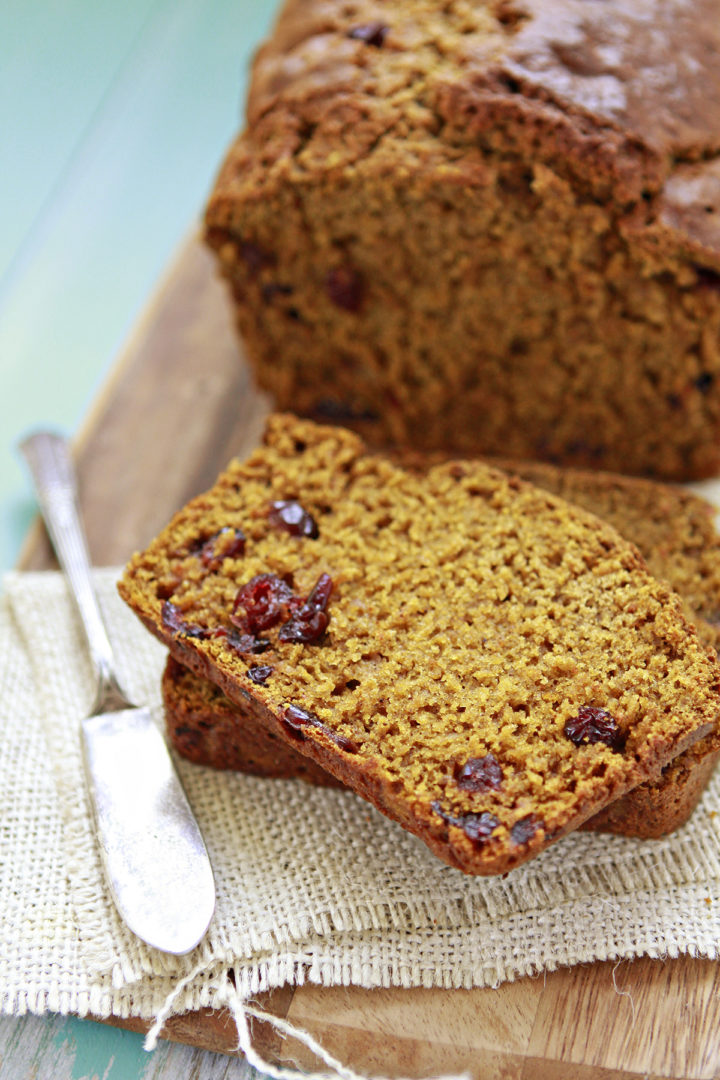 sliced pumpkin cranberry bread with a butter knife