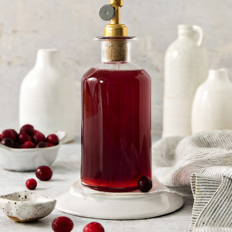 cranberry simple syrup in a glass bottle