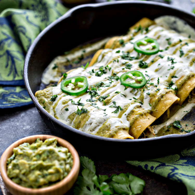 cast iron pan with salsa verde enchiladas