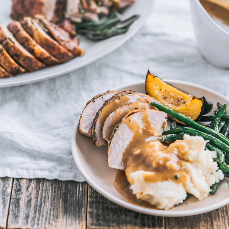 a plate with smoked turkey, mashed potatoes, and green beans