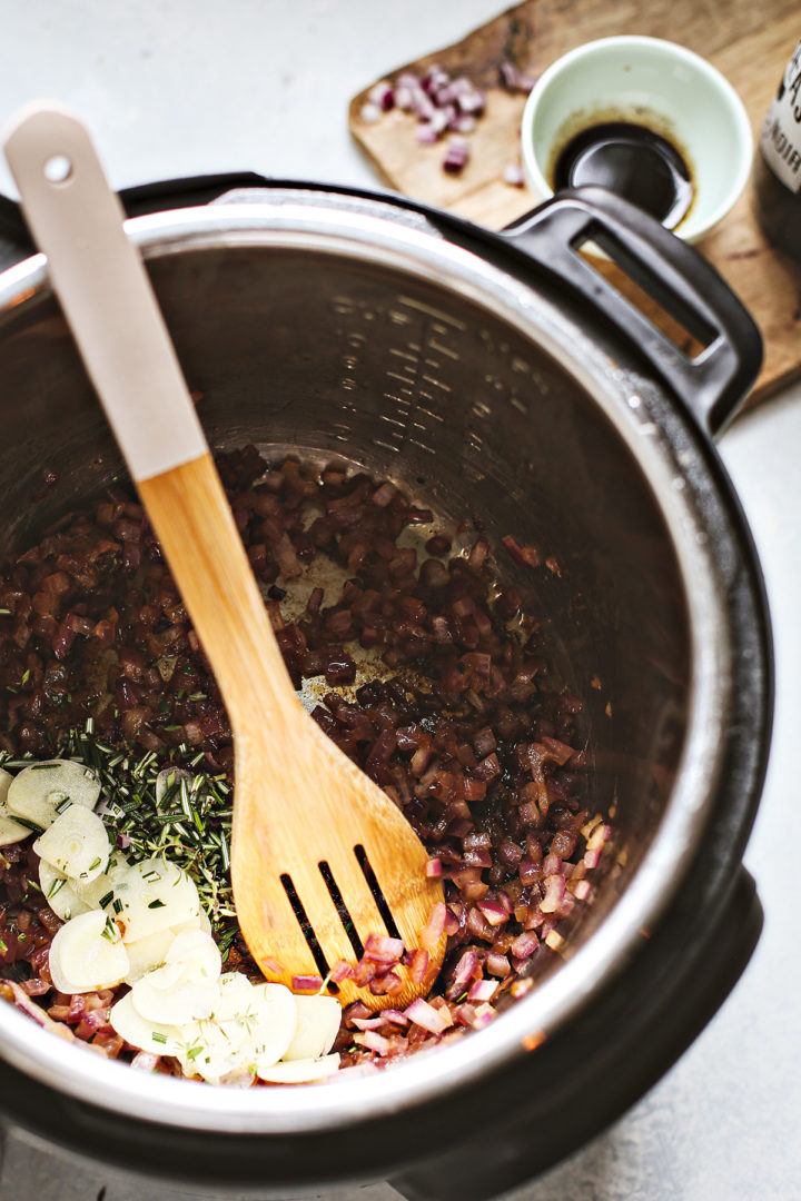 adding garlic and rosemary to the instant pot roast