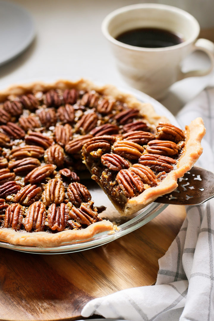 slice of bourbon pecan pie being served from a pie plate